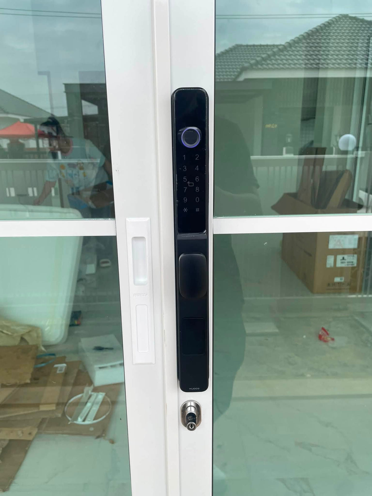 Black short-handle smart door lock fitted to a white framed glass door